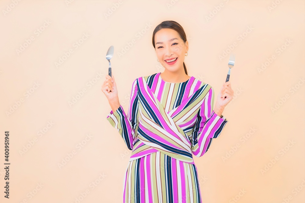 Portrait beautiful young asian woman with fork and spoon ready to eat Portrait beautiful young asian woman with fork and spoon ready to eat
