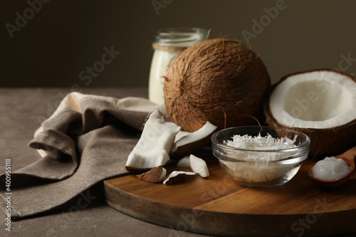 Board with coconut and coconut flakes on gray table