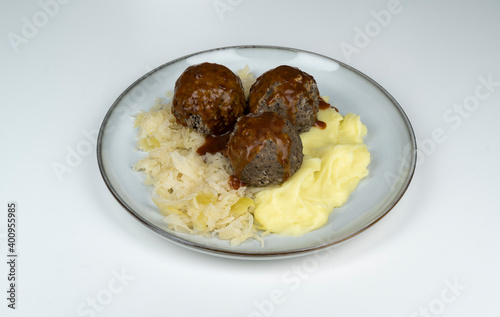 Eine Portion gekochter, pfälzer Leberknödel mit Sauerkraut, Kartoffelpüree und brauner Sauce,