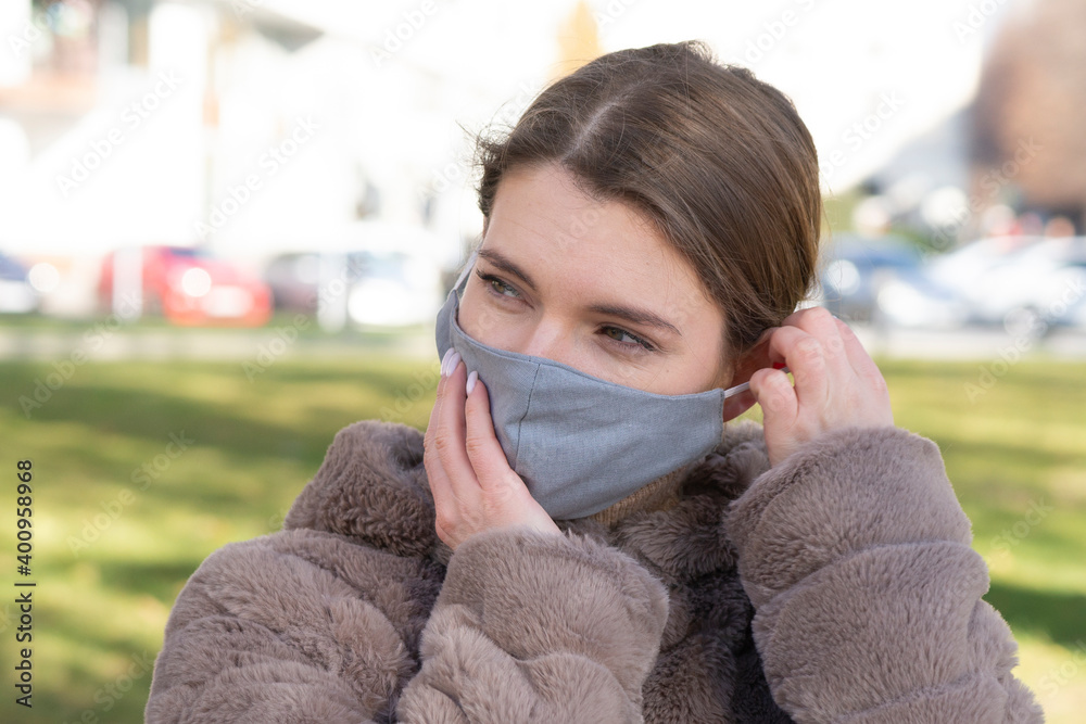 Beautiful stylish girl wear medical face mask on sunny city street. Young elegant happy hipster woman put on protective face mask outdoors. Urban fashion outfit, lifestyle. Beautiful stylish girl wear medical face mask on sunny city street. Young elegant happy hipster woman put on protective face mask outdoors. Urban fashion outfit, lifestyle.