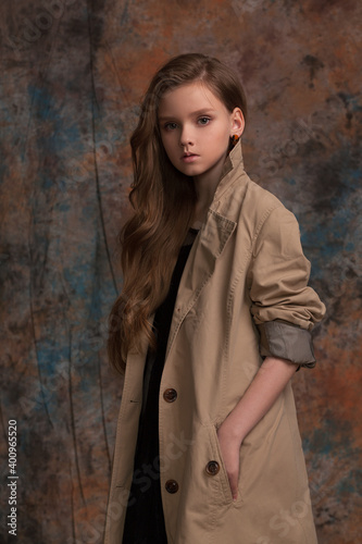 beautiful girl in a raincoat posing in the studio on a spotted background