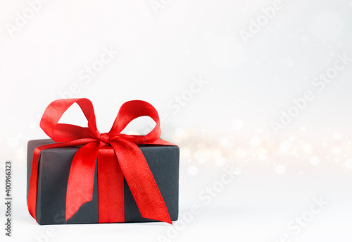 gift box with red bow on defocus lights background © Ирина Гутыряк