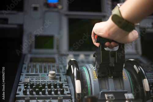 Cropped hands of pilot flying a commercial airplane, cockpit view close up of hands. Captain hand accelerating on the throttle in commercial airplane