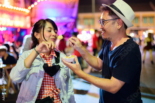 Photography Asian couple enjoy eating on the street food at Khao San road