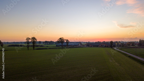Wallpaper Mural Dramatic and colorful sunrise or sunset sky over a grassy green farmfield shot from drone high up. High quality photo Torontodigital.ca