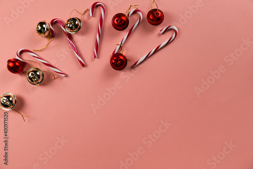 Top view of Christmas bells with many candy cane on pastel pink background.Holiday festive celebration greeting card with copy space to addng text photo