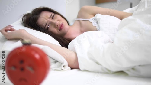A young woman wakes up from the alarm clock
