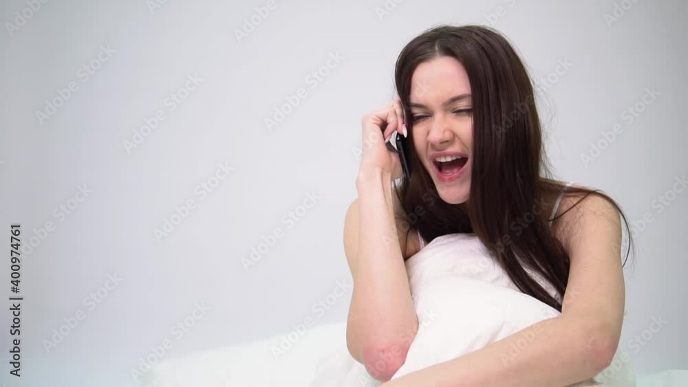 Young woman screams in displeasure into the receiver Young woman screams in displeasure into the receiver