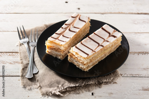 Millefoglie or French mille-feuille on white wooden table	 photo