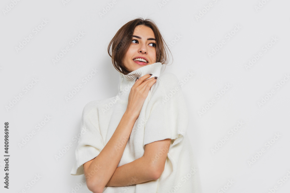 Tender. Portrait of beautiful brunette woman in comfortable soft longsleeve isolated on white studio background. Home comfort, emotions, facial expression, winter mood concept. Copyspace.