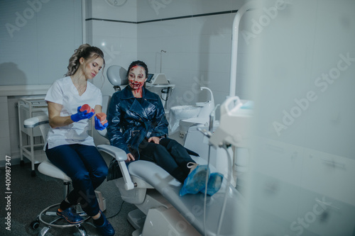 Woman in image of ugly mutant treats her teeth in dental clinic.
