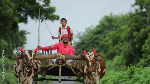 Indian farmer and his child on bullock cart