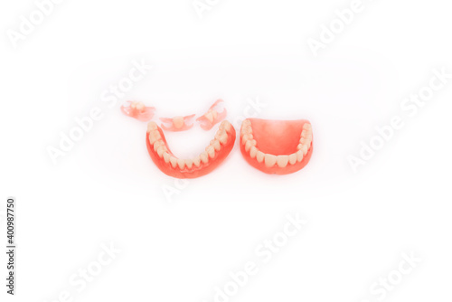 Dentures on a white background. Close-up of dentures. Full removable plastic denture of the jaws. Prosthetic dentistry. False teeth. Close-up of plastic dentures. Teeth on a white background