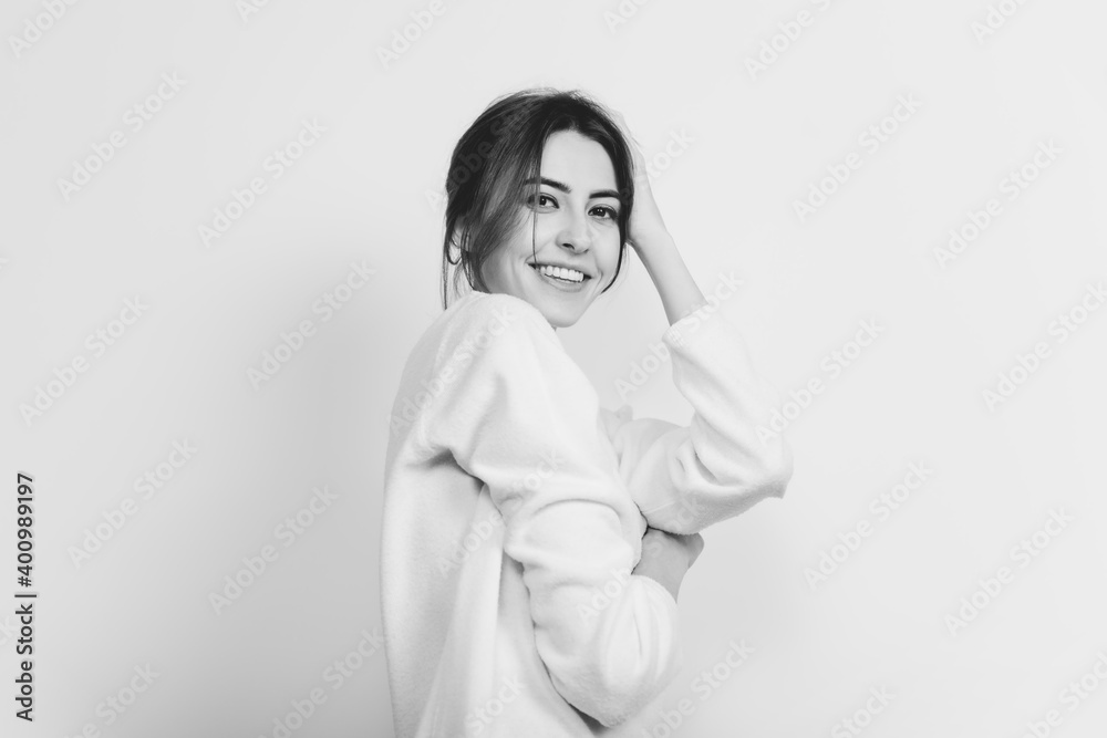 Smiling. Portrait of beautiful brunette woman in comfortable soft longsleeve on studio background, black and white. Home comfort, emotions, facial expression, winter mood concept. Copyspace. Smiling. Portrait of beautiful brunette woman in comfortable soft longsleeve on studio background, black and white. Home comfort, emotions, facial expression, winter mood concept. Copyspace.