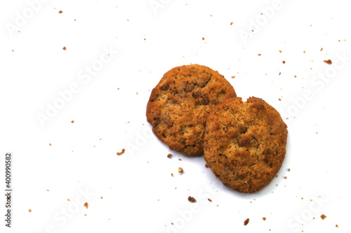 Raisin-topped circle cookies with cookie powder scattered around, isolated on a white background