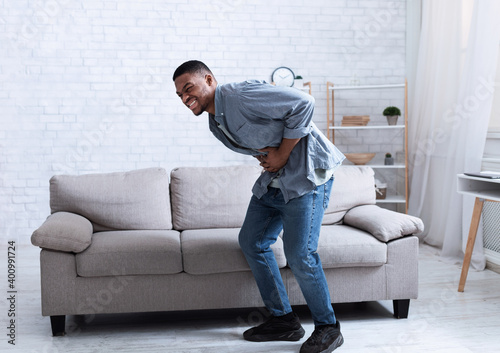 Black Man Having Stomachache Suffering From Abdominal Spasm At Home © Prostock-studio