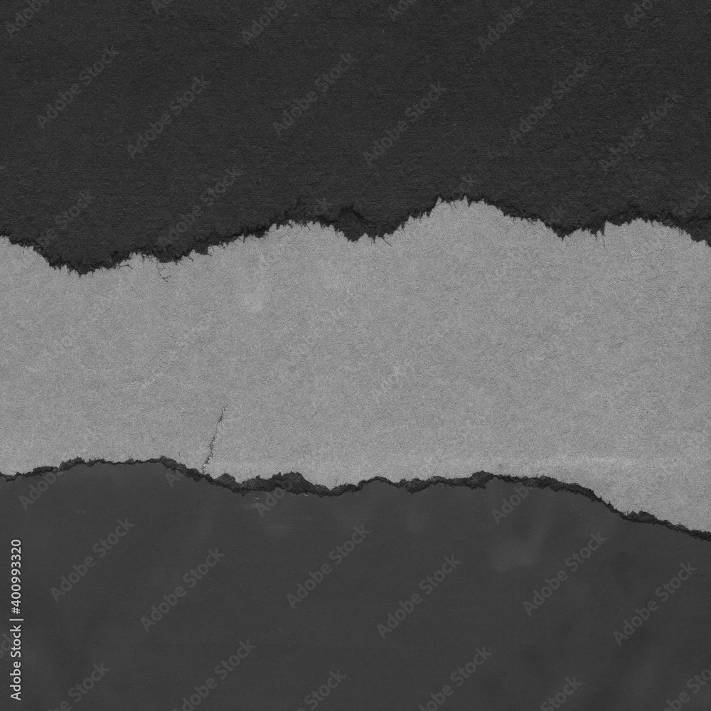 Black torn paper collage close-up. Texture made from various paper and cardboard parts. Damaged old paper background. Vintage blank wallpaper. Material design backdrop.