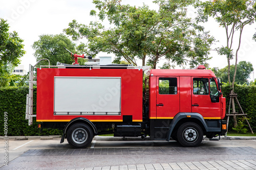 Side view of red fire truck parking on the road
