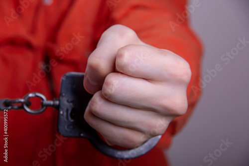 Fotografie THE HAND OF A TEENAGER IN HANDCUFFS