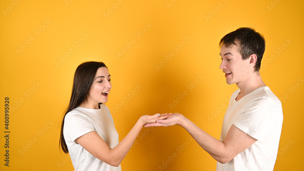 A man with a woman hold together an empty space in their hand A man with a woman hold together an empty space in their hand