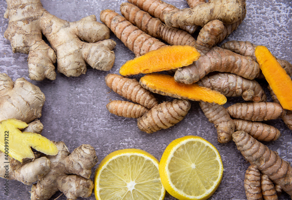 Fresh turmeric root, ginger, oranges and lemon on a grey slate background. Fresh turmeric root, ginger, oranges and lemon on a grey slate background.