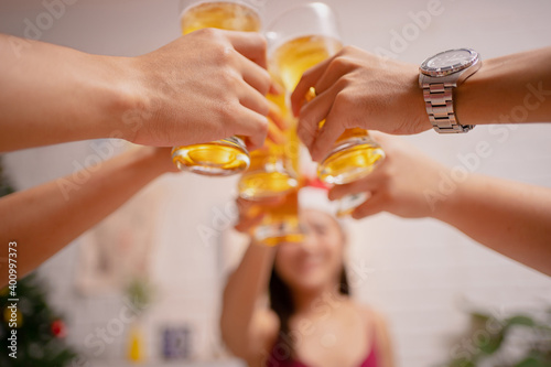 Close-up picture of a group of Asian friends holding a glass of beer.