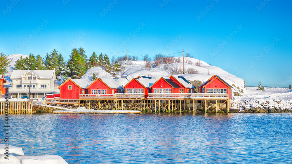 Traditional Norwegian red wooden houses on the shore of  Reinefjorden near Hamnoy village