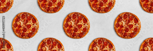 Tasty pizza seamless pattern banner on bright concrete surface.Top view of pepperoni sliced pizza. 