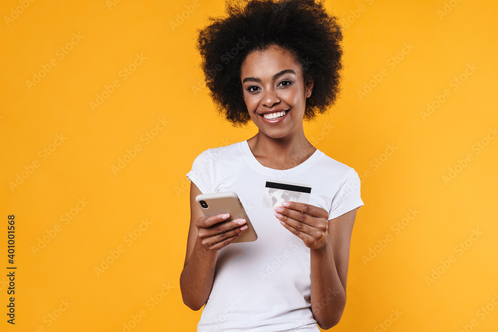 Happy young african american woman holding cellphone and credit card Happy young african american woman holding cellphone and credit card