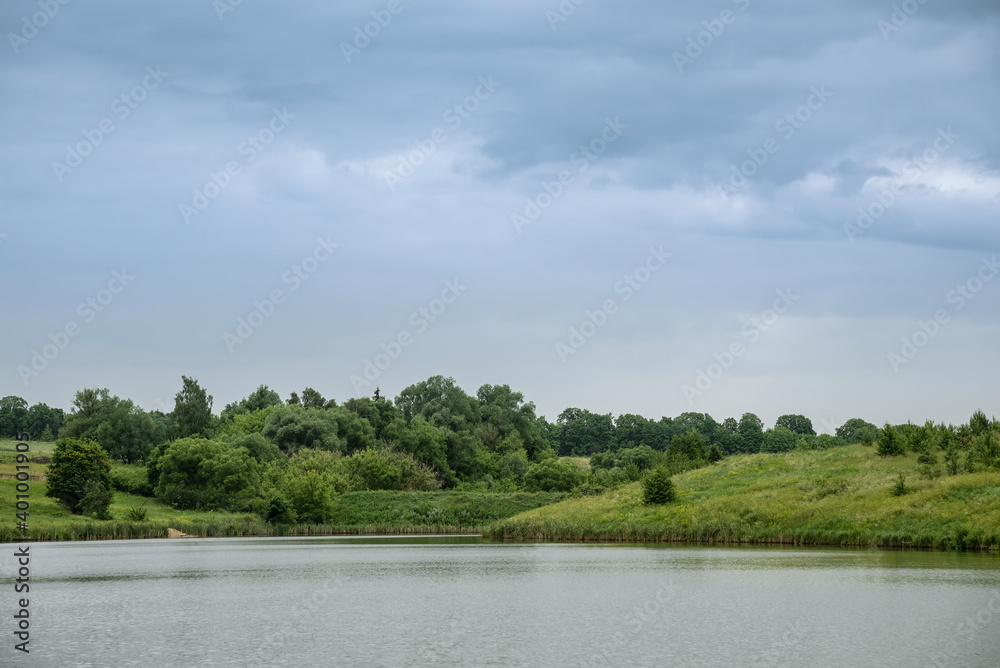 Fototapeta premium Landscape with lake, forest and rain clouds.
