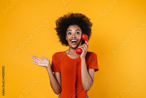 African american girl holding copyspace and talking on retro phone