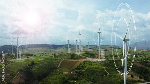 Aerial view of windmills with digitally generated holographic display tech data visualization. Wind power turbines generating clean renewable energy for sustainable development in a green ecologic way