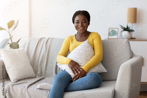 Day At Home. Smiling Black Woman Sitting On Comfortable Couch With Pillow