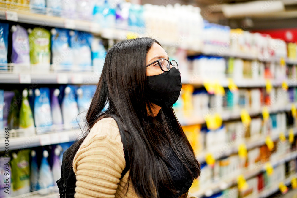 portrait of beautiful girl in glasses and mask in the supermarket, supermarket shopping concept