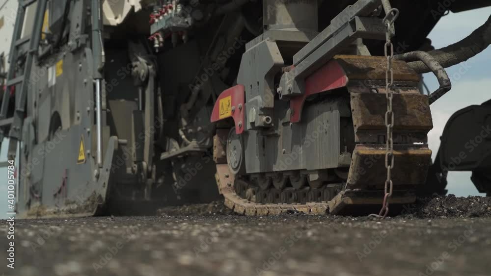 tracked road milling machine in motion on the road. closeup tracked road milling machine in motion on the road. closeup