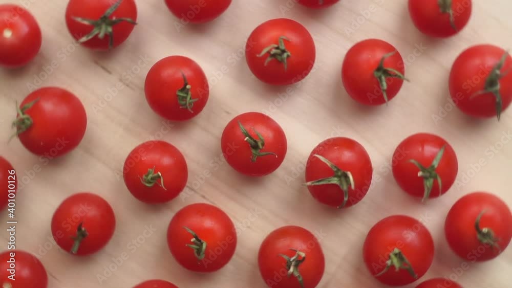 Rotating cherry tomatoes on a wooden table background. Food video background. Flat lay minimal concept. Rotating cherry tomatoes on a wooden table background. Food video background. Flat lay minimal concept.