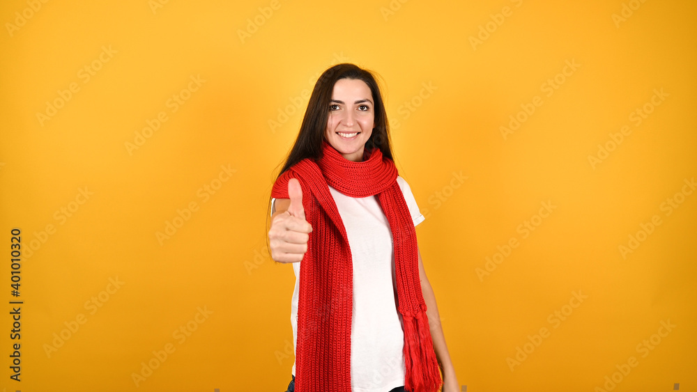 Girl showing thumbs up on yellow background Girl showing thumbs up on yellow background