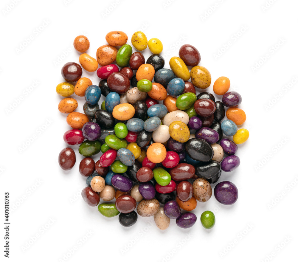 A heap of multi-colored glazed raisins on a white background. Rounded candies of different colors and sizes. Healthy and tasty snack. A heap of multi-colored glazed raisins on a white background. Rounded candies of different colors and sizes. Healthy and tasty snack.