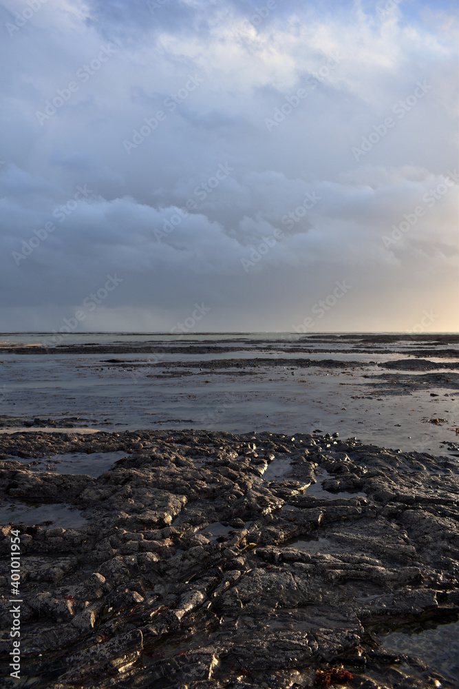 stormy clouds coming over a low tide beach in Normandy 