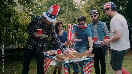Friends taking food at a 4th of July picnic