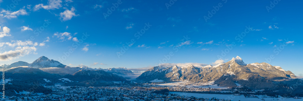 Panorama at sunrise in reutte on a winter's day with mountains thaneller and hahnenkamm