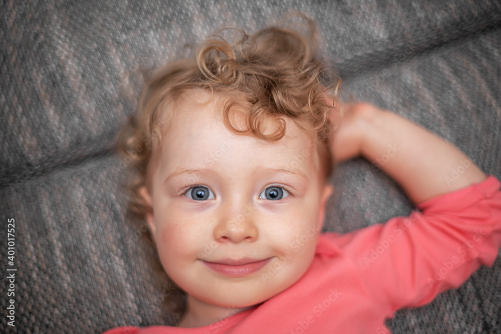 Smiling child lies on the sofa. The girl smiles. Smiling child lies on the sofa. The girl smiles.
