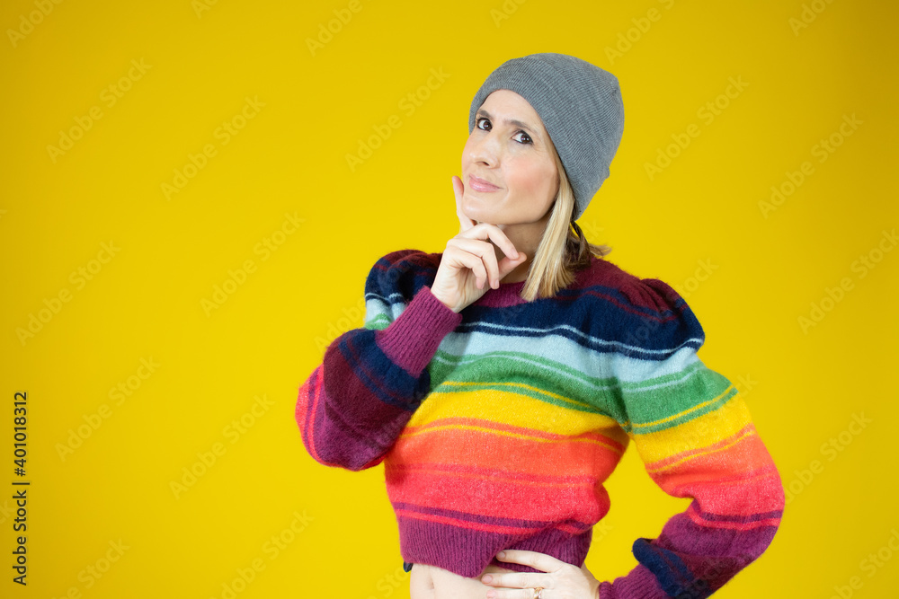 Young woman in winter clothes with doubtful gesture standing over yellow background. Young woman in winter clothes with doubtful gesture standing over yellow background.