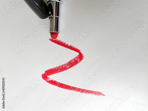 Smear of red lipstick with microplastic particles on a white background photo
