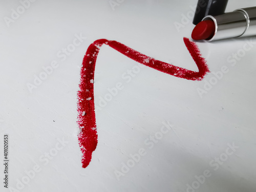 Smear of red lipstick with microplastic particles on a white background photo