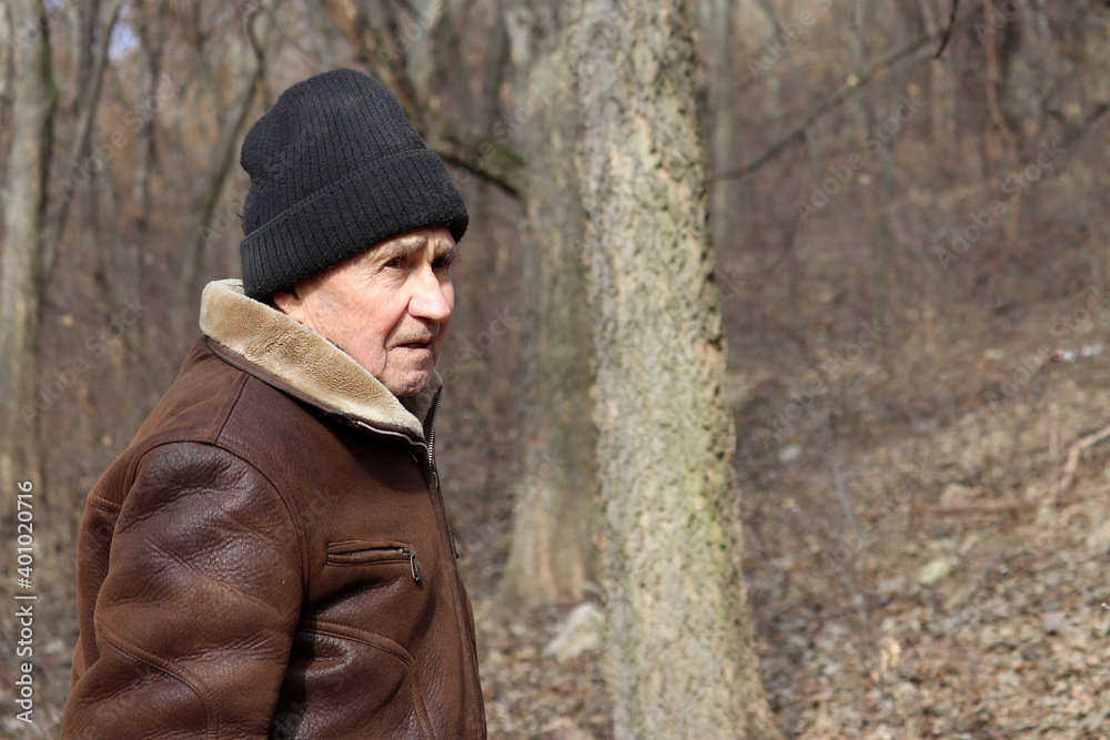 Portrait of elderly man standing in winter forest. Concept of old age, life in village Portrait of elderly man standing in winter forest. Concept of old age, life in village