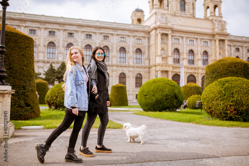 Photography Beautiful happy young women with cute small dog puppy have fun on street