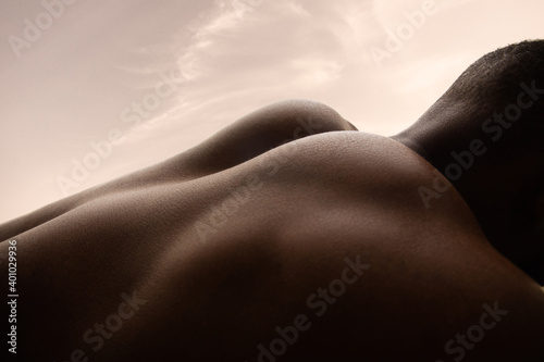 Morning. Detailed texture of human skin. Close up of young african-american male body surface like landscape with the sky on background. Skincare, bodycare, healthcare, inspiration, fantasy artwork.