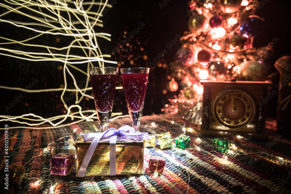 Red wine in crystal glass with bottle on colorful carpet with creative New Year artwork decorations. Copy space Red wine in crystal glass with bottle on colorful carpet with creative New Year artwork decorations. Copy space