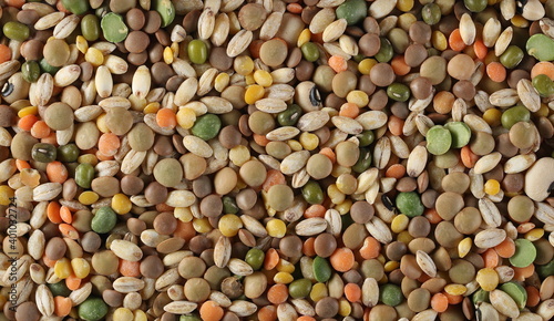Mixed legumes and cereals, peeled barley, green, yellow and dark red lentils, half green peas, black white beans, green beans background and texture, top view